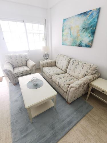 a living room with a couch and a table at Gregorys Poolside Villa in Sucina