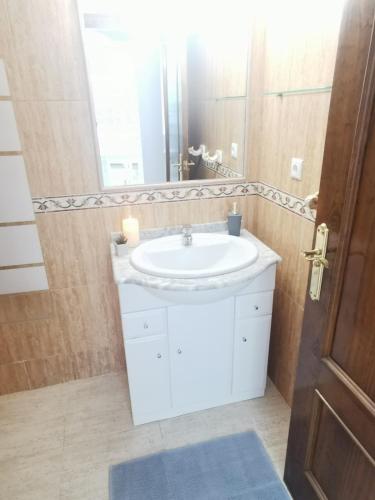 a bathroom with a white sink and a mirror at Gregorys Poolside Villa in Sucina