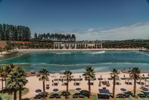 an overhead view of a large swimming pool with palm trees at Boa Vista Surf Lodge in Pôrto Feliz