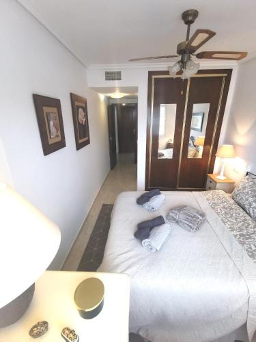a bedroom with a large white bed with a ceiling fan at Gregorys Poolside Villa in Sucina