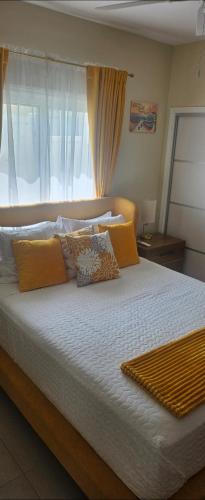 a bedroom with a large bed with yellow pillows at Blue Water Villa in Point