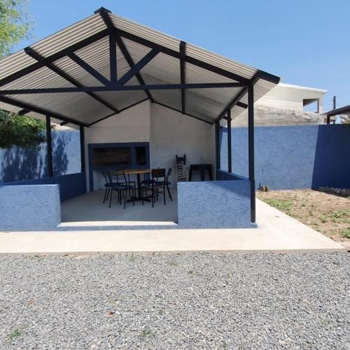 a pavilion with tables and chairs under a roof at Tres Lunas in La Falda