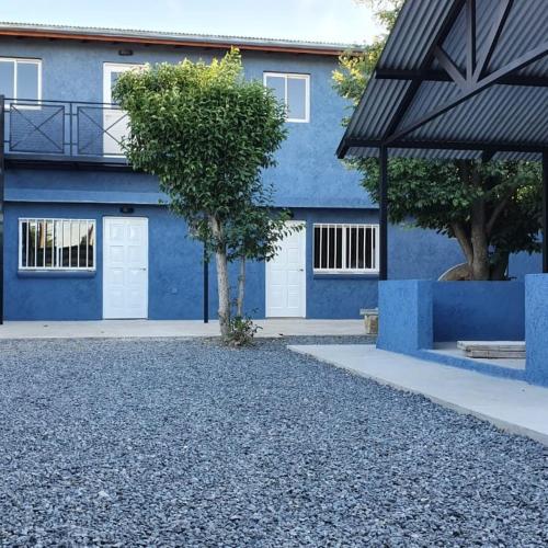 a blue building with a tree in front of it at Tres Lunas in La Falda