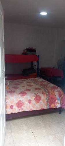1 dormitorio con 1 cama con manta de flores en Tres Lunas, en La Falda