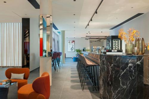 a lobby with a bar with orange chairs at DAS AFFALTERBACH, Stuttgart, Autograph Collection in Affalterbach