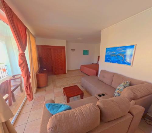 a living room with a couch and a bed at West Bay Colonial in West Bay