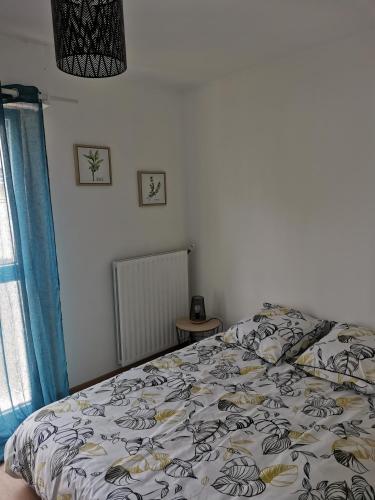 une chambre avec un lit avec une couette dessus dans l'établissement Appartement à 5 min du port, à Vannes