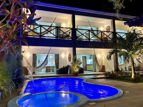 a large blue pool in front of a house at Villa Bangalu Exclusiva para Adultos in Porto De Galinhas