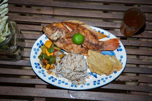 a plate of food with a fish on a table at Taironaka Eco Hotel in Don Diego