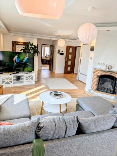 a living room with two couches and a tv at Luxury Villa 130 m2 centrally in Katrineholm
