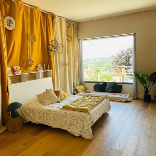 une chambre avec un lit et une grande fenêtre dans l'établissement Nature loft, calme et confortable, à La Murette
