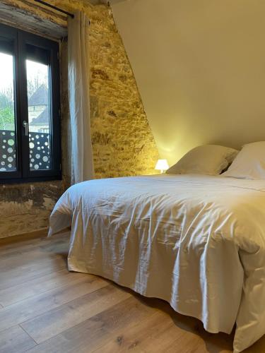une chambre avec un lit et un mur de briques dans l'établissement Vacances à Sarlat, à Sarlat-la-Canéda