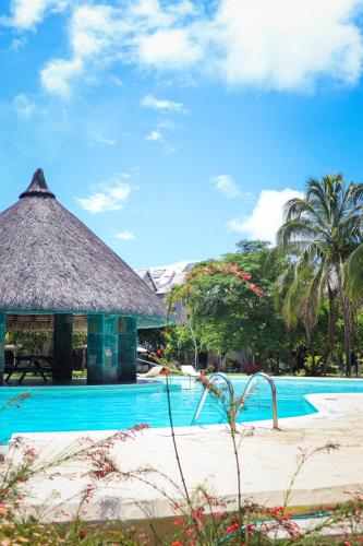 a resort with a swimming pool and a hut at Beach Retreat by C in Bain Boeuf