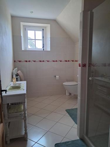 une salle de bain avec un lavabo et des toilettes et une fenêtre dans l'établissement Chez Mylene, à Huismes