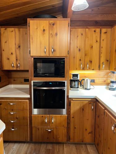 a kitchen with wooden cabinets and a microwave at April Point Harbour House in Quathiaski Cove