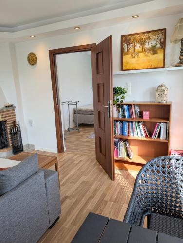 a living room with a couch and a book shelf with books at Luxury Villa 130 m2 centrally in Katrineholm
