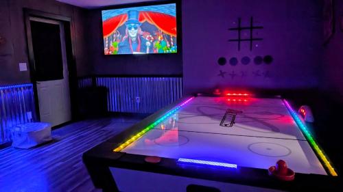 a room with a table with a video game at Lil Cabin in the Cove! MTN views, theater, hot tub, games, king beds, Prime Location! in Sevierville