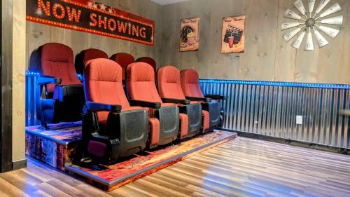 an empty theater with red chairs in a room at Lil Cabin in the Cove! MTN views, theater, hot tub, games, king beds, Prime Location! in Sevierville
