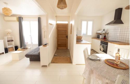 une cuisine et un salon avec une table dans une pièce dans l'établissement Charmante Maison de village Clim et Wifi, à Mauguio