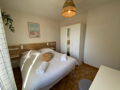 Un dormitorio con una cama blanca con dos almohadas. en Appartement Port Hyères 2 ch terrasses box, en Hyères