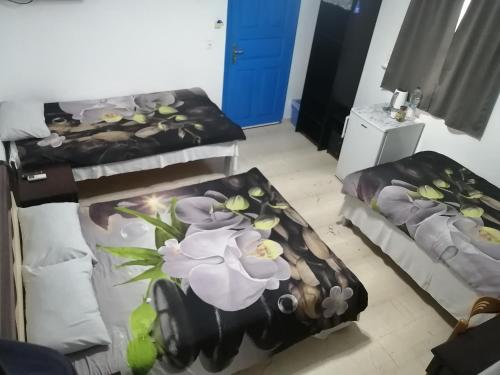a room with two beds with flowers on it at The Best in Perissa