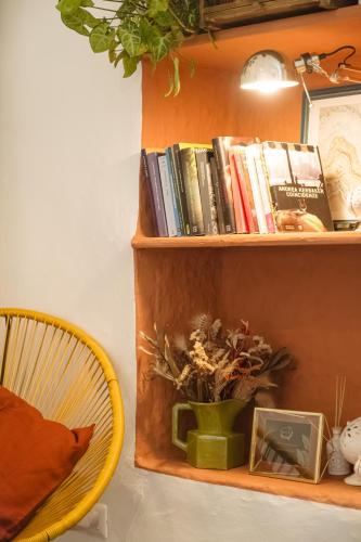 a book shelf with books and a chair on it at CALMAPIANTA home for green lovers in Putignano