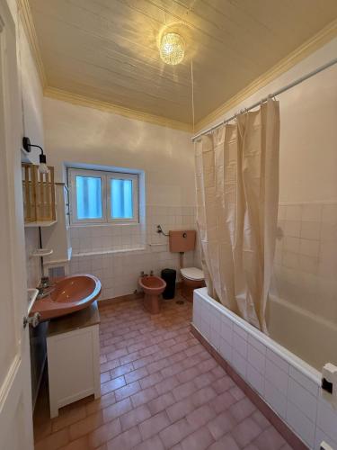 a bathroom with a tub and a toilet and a sink at Casa das Muralhas in Peniche