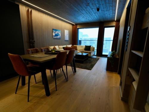 a dining room with a table and chairs and a couch at Ski in & out - Hemsedal in Kyrkjebøen