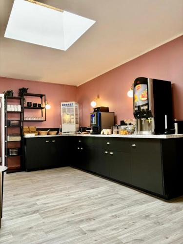 a kitchen with black cabinets and a counter top at Hotel du Saumon, Verneuil sur Avre in Verneuil d’Avre et d’Iton