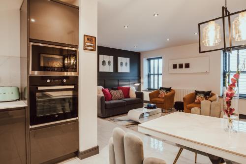 a living room with a kitchen and a living room with a fireplace at The Penthouse Luxury Central Apartment in Glossop