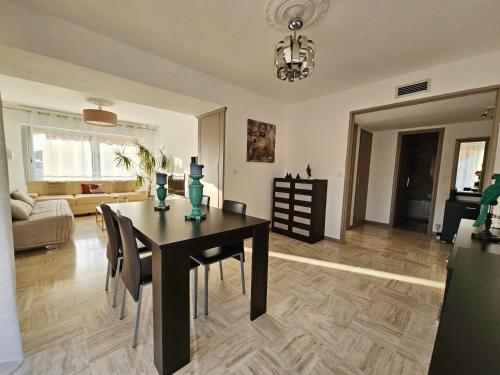 - une table à manger et des chaises dans le salon dans l'établissement Superbe 2 pièces 70m parking privé climatisation, à Saint-Laurent-du-Var