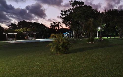 a yard with a pool in a park at night at Samburá Chalés in Ilha Comprida