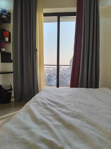 Un dormitorio con una cama blanca y una ventana. en Hotel Omaxe Hazratganj, en Nalmatha