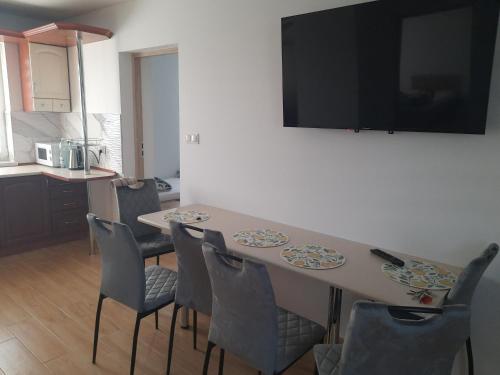 a dining room with a table with chairs and a television at Gospodarstwo Agroturystyczne in Kołacznia