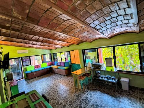 a room with colorful chairs and a table and windows at Casa Rosa in Sayulita