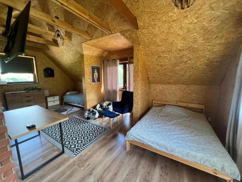 a bedroom with a bed and a table in a room at Domek LuźnAgro Góry Sowie in Łomnica