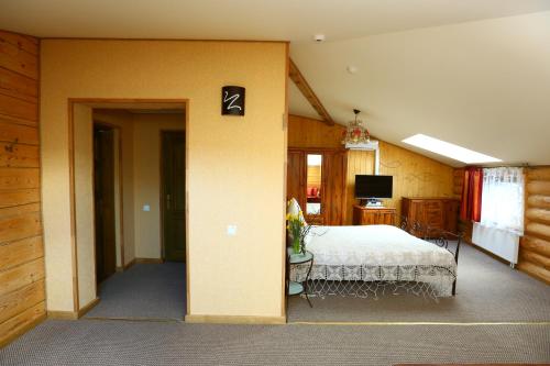 a bedroom with a bed and a table and a television at Arciau Juros in Palanga