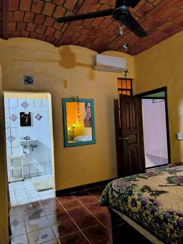 a bedroom with a bed and a room with a door at Casa Rosa in Sayulita