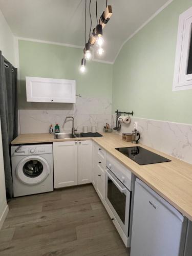 une cuisine avec un évier et une machine à laver dans l'établissement Lili-Belle, maison de vacances, à Livinhac-le-Haut