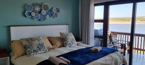 a bedroom with a bed with a view of the water at 109 at Breede in Witsand