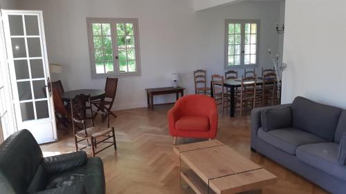 - un salon avec un canapé et un fauteuil rouge dans l'établissement La Pantaine, à Cénac-et-Saint-Julien
