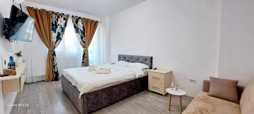 a small bedroom with a bed and a couch at Relax Home apartments in Iaşi