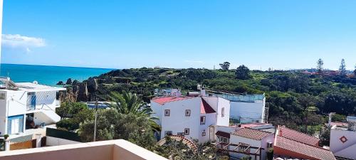 a group of buildings on a hill next to the ocean at Dona Ana Beach - Dream Flat in Lagos
