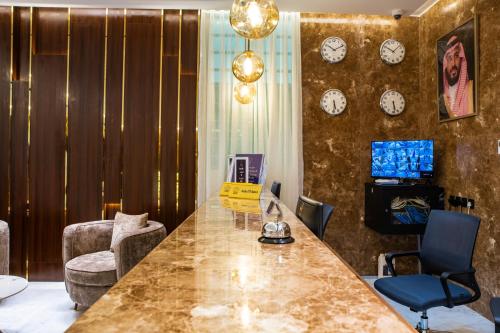 a living room with a table and clocks on the wall at فندق فجر الواحة in Riyadh