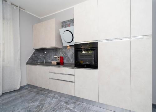 a kitchen with white cabinets and a stove at Villa Caruso in Massa Lubrense