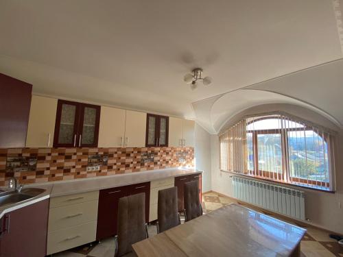 an empty kitchen with a table and a window at Vila Lena in Cahul