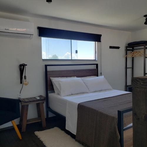 a bedroom with a large bed and a window at loft charmoso com lareira, a beira mar in Balneário Gaivotas