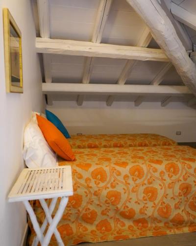 a bedroom with a bed with an orange bedspread at Borgo Pallavicini Mori in Prima Porta