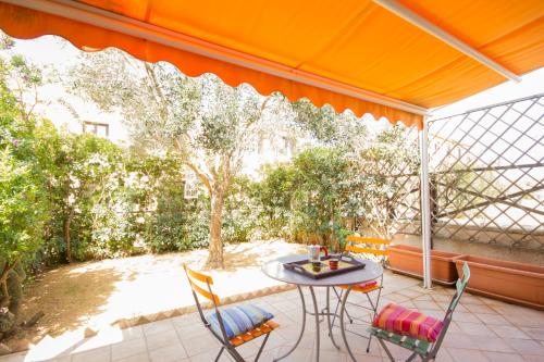 een patio met een tafel en stoelen op een veranda bij Stagnone Holiday Apartment in Birgi Vecchi