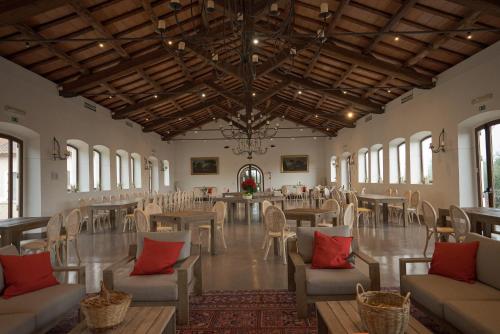 a large room with tables and chairs and windows at Borgo Pallavicini Mori in Prima Porta